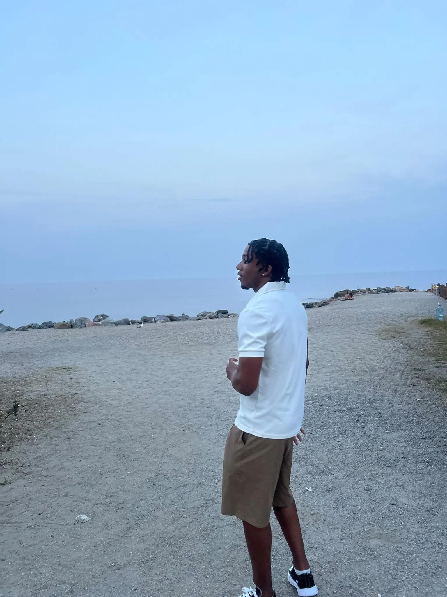 Emo Zignego su una spiaggia al tramonto, di profilo verso il mare